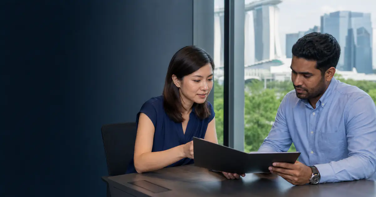 Professional and adviser reviewing documents in a Singapore office